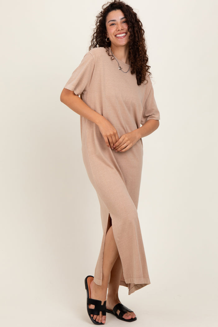 woman wearing a beige short sleeve maxi dress with side slits and standing in black sandals