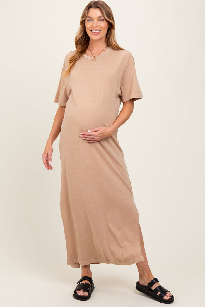 woman wearing a beige short sleeve maternity maxi dress and holding her baby bump