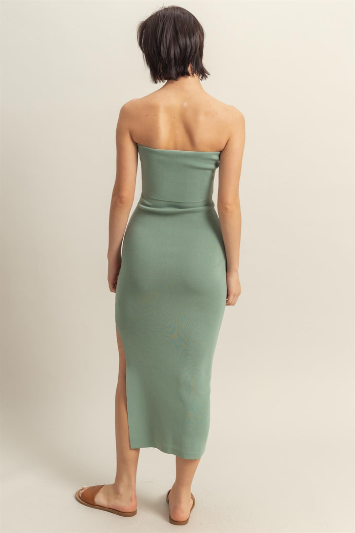 woman wearing a mint green strapless midi dress with a side slit, shown from the back