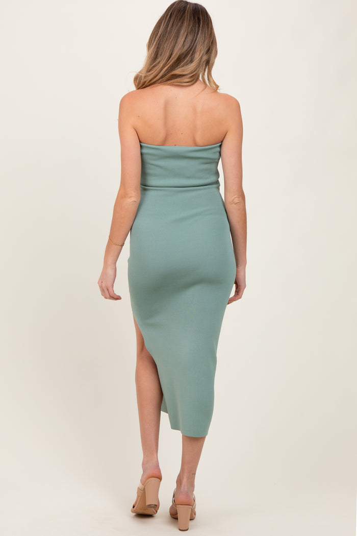 woman wearing a mint green strapless maternity dress with a side slit, showing her back