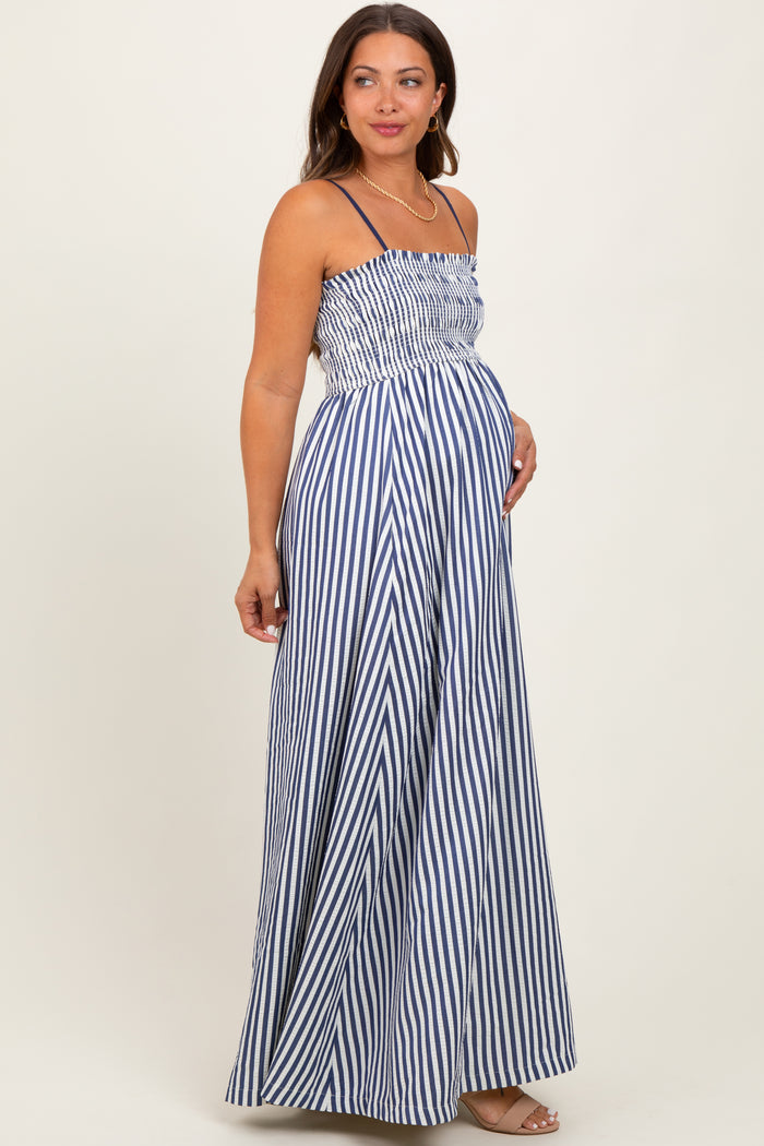 woman wearing a navy and white striped maternity maxi dress with a smocked bodice and a visible baby bump