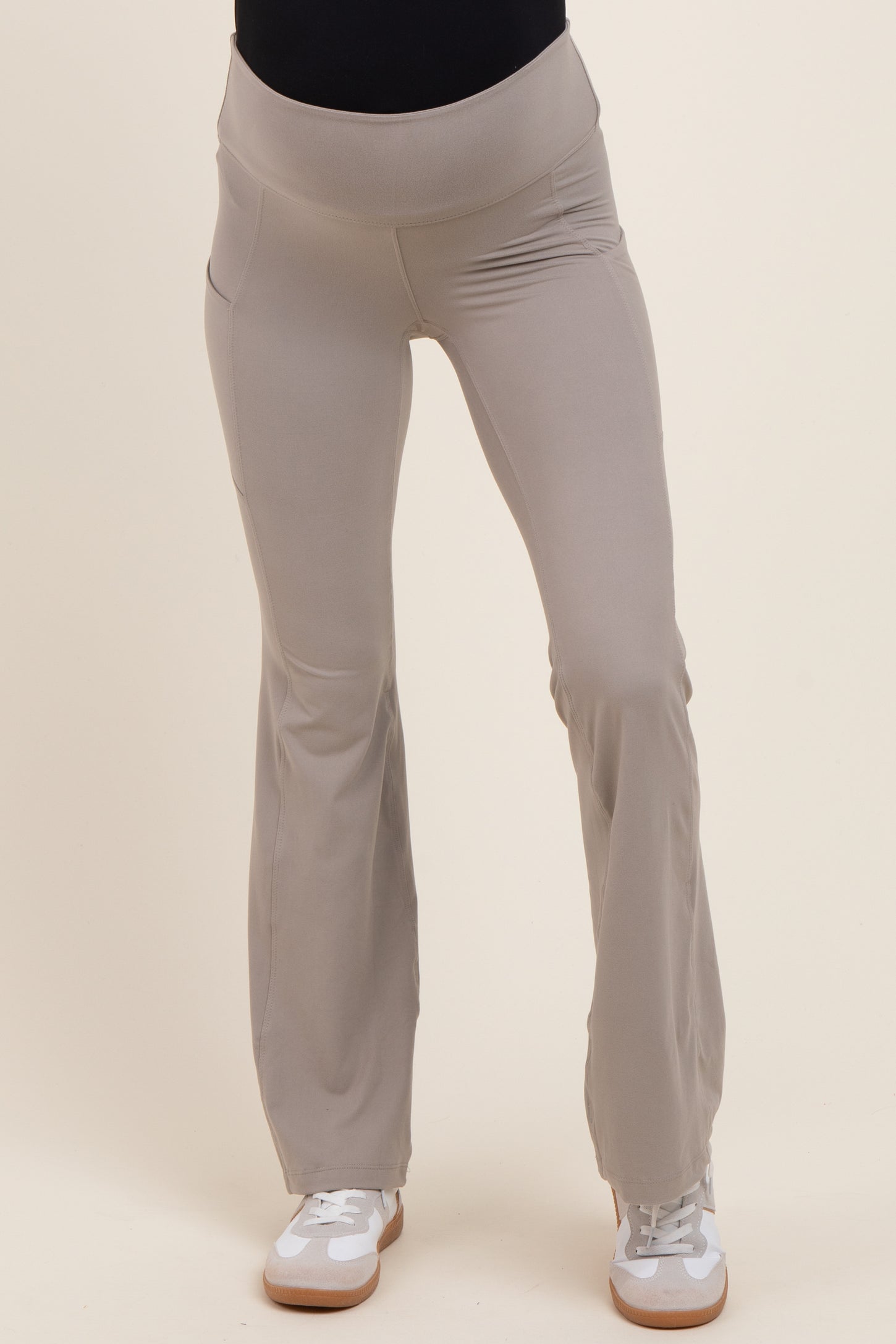 woman wearing light beige maternity activewear pants with a comfortable waistband and flared legs
