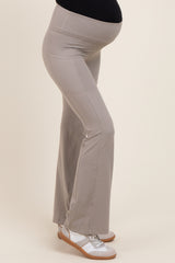 maternity wear light grey flared pants with a supportive waistband and a visible baby bump