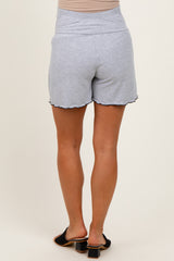 woman wearing light blue maternity shorts with a scalloped hem and a stretch waistband, showing her back