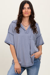 woman wearing a navy blue striped oversized short sleeve top with a collar and front pocket