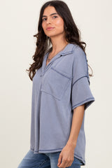 woman wearing a blue striped oversized short sleeve top with a front pocket and a relaxed fit