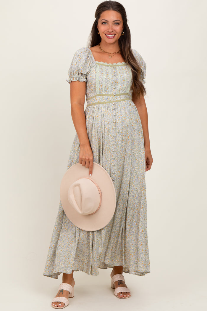 woman wearing a floral maternity maxi dress with puff sleeves and a matching hat, showcasing her baby bump