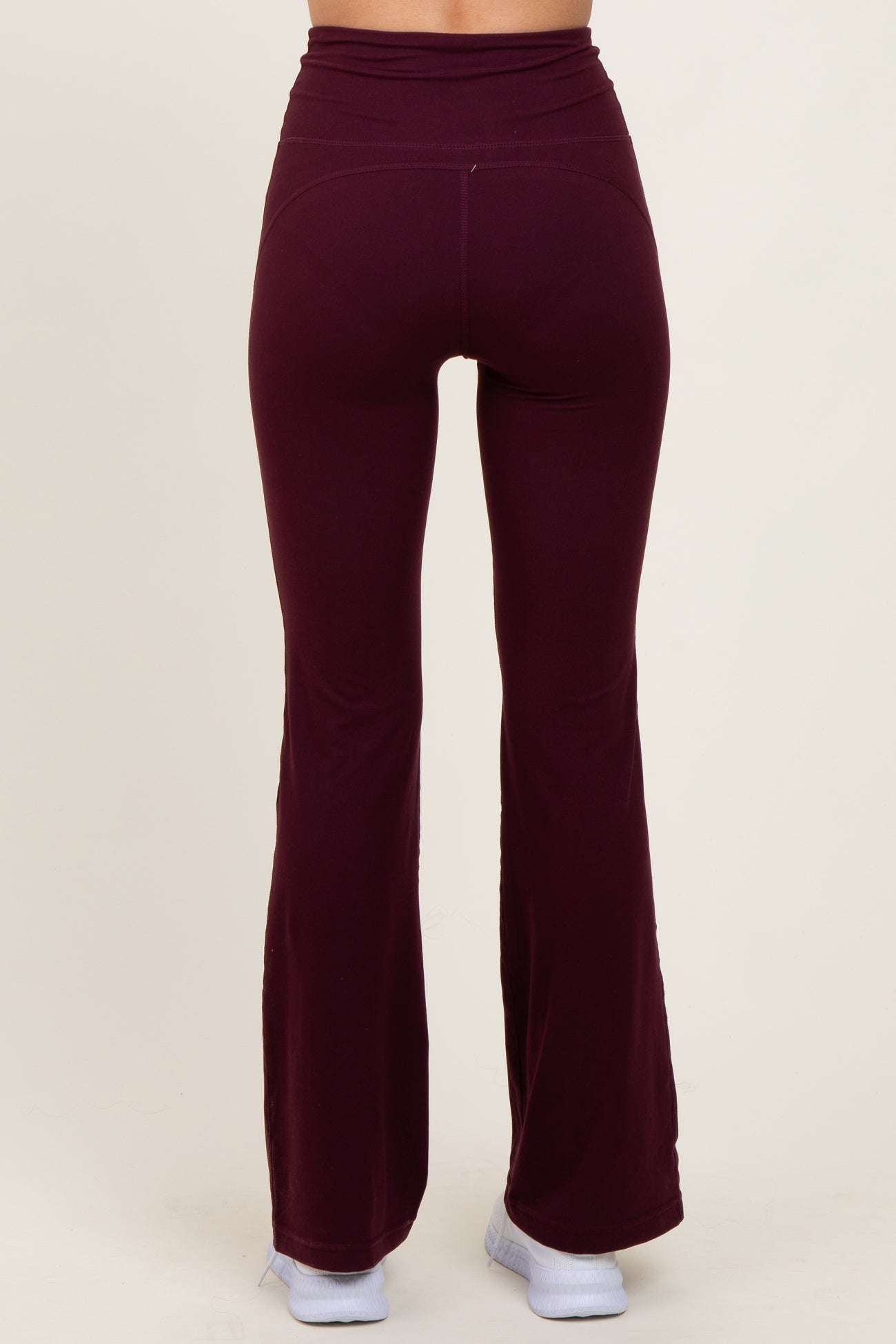 woman wearing burgundy flared leggings with a high waistband, viewed from the back