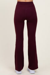 woman wearing burgundy flared leggings with a high waistband, viewed from the back