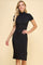 woman wearing a black ribbed short sleeve bodycon dress with a high collar