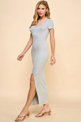 woman wearing a fitted gray maxi dress with short sleeves and a side slit, posing against a neutral background