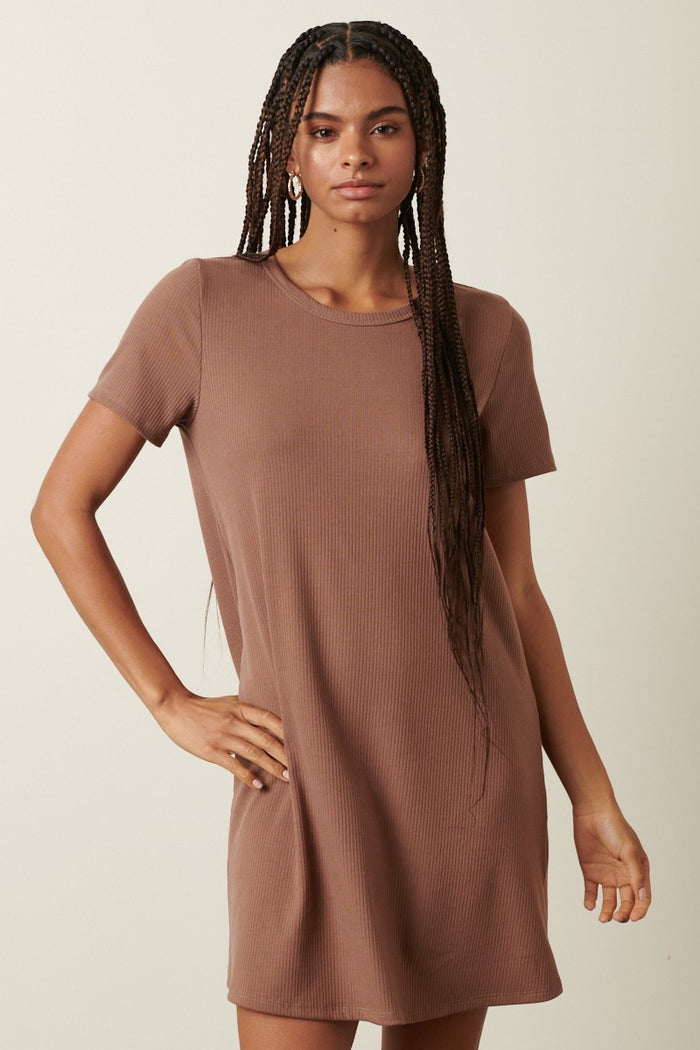woman wearing a short sleeve brown ribbed t-shirt dress standing with one hand on her hip