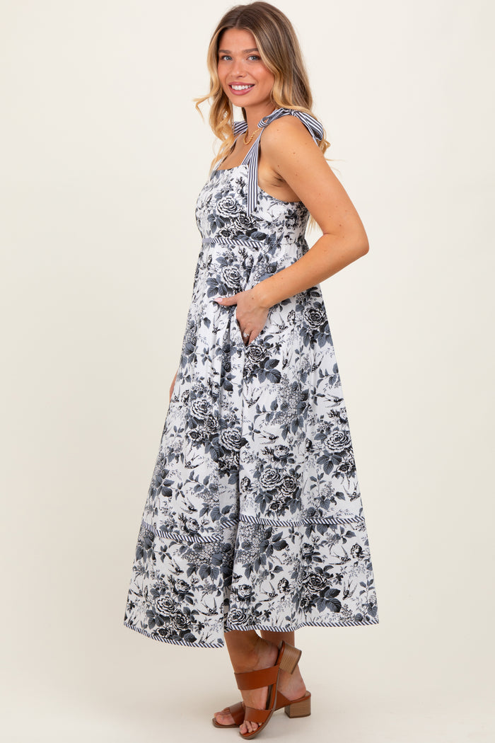 woman wearing a floral print maxi dress with tie shoulder straps and pockets, standing sideways
