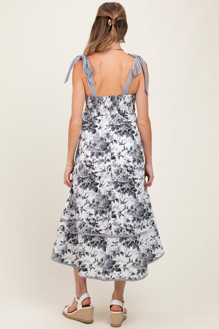woman wearing a floral print maternity dress with back tie details and a flowing skirt