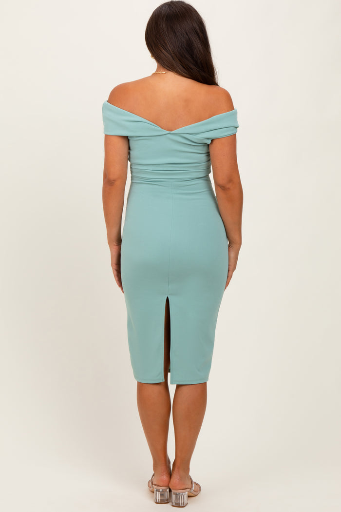 woman wearing a light blue off-the-shoulder maternity dress with a back slit, showing a baby bump from the back