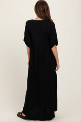 woman wearing a black maxi dress with short sleeves and a cinched waist, seen from the back