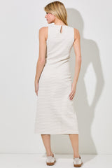 woman wearing a cream striped sleeveless midi dress with a keyhole back detail