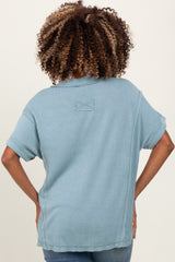 woman wearing a light blue short sleeve ribbed maternity top, showing the back view, with a relaxed fit