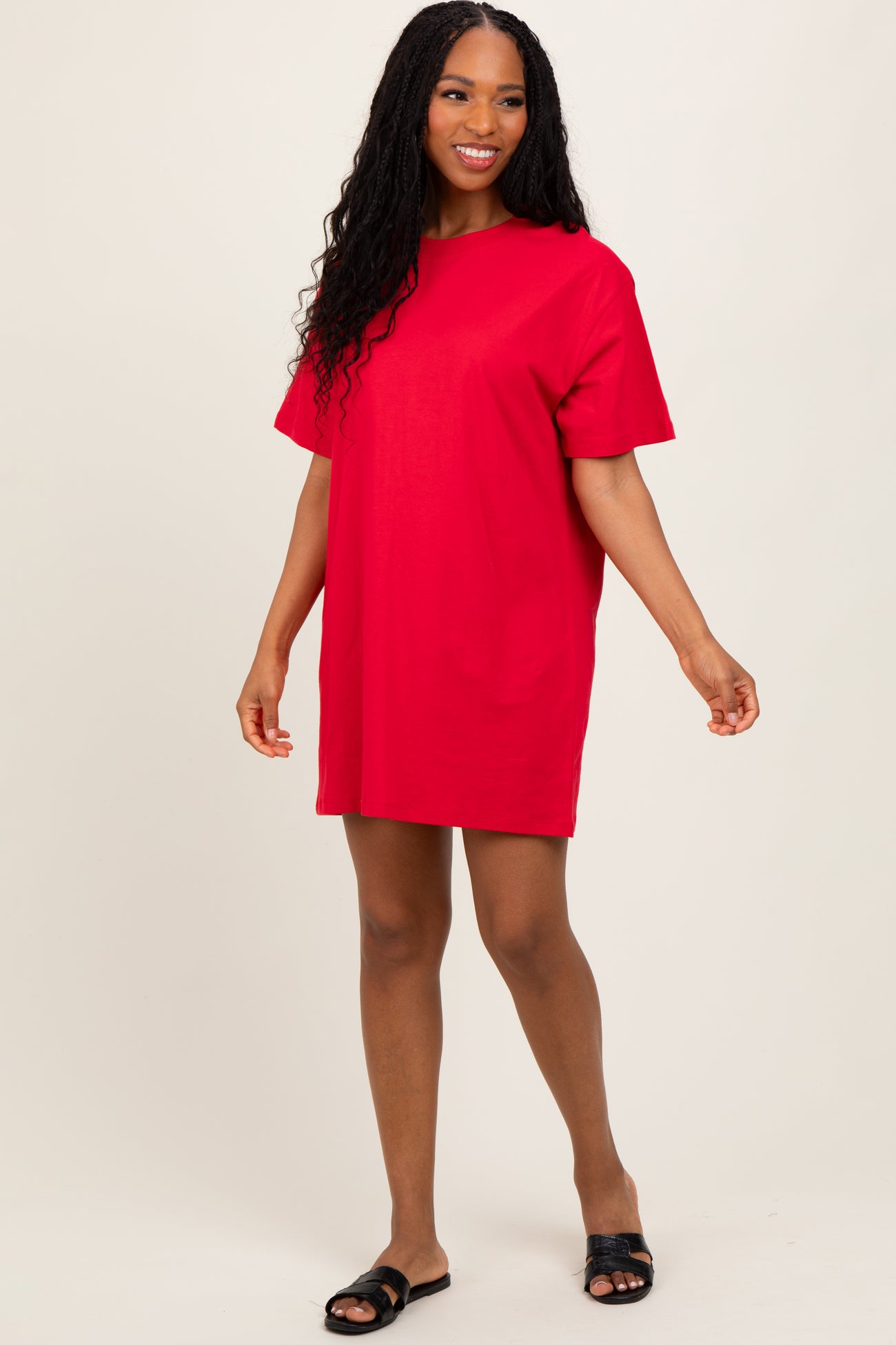 woman wearing a vibrant red short sleeve t-shirt dress with a relaxed fit and black slide sandals