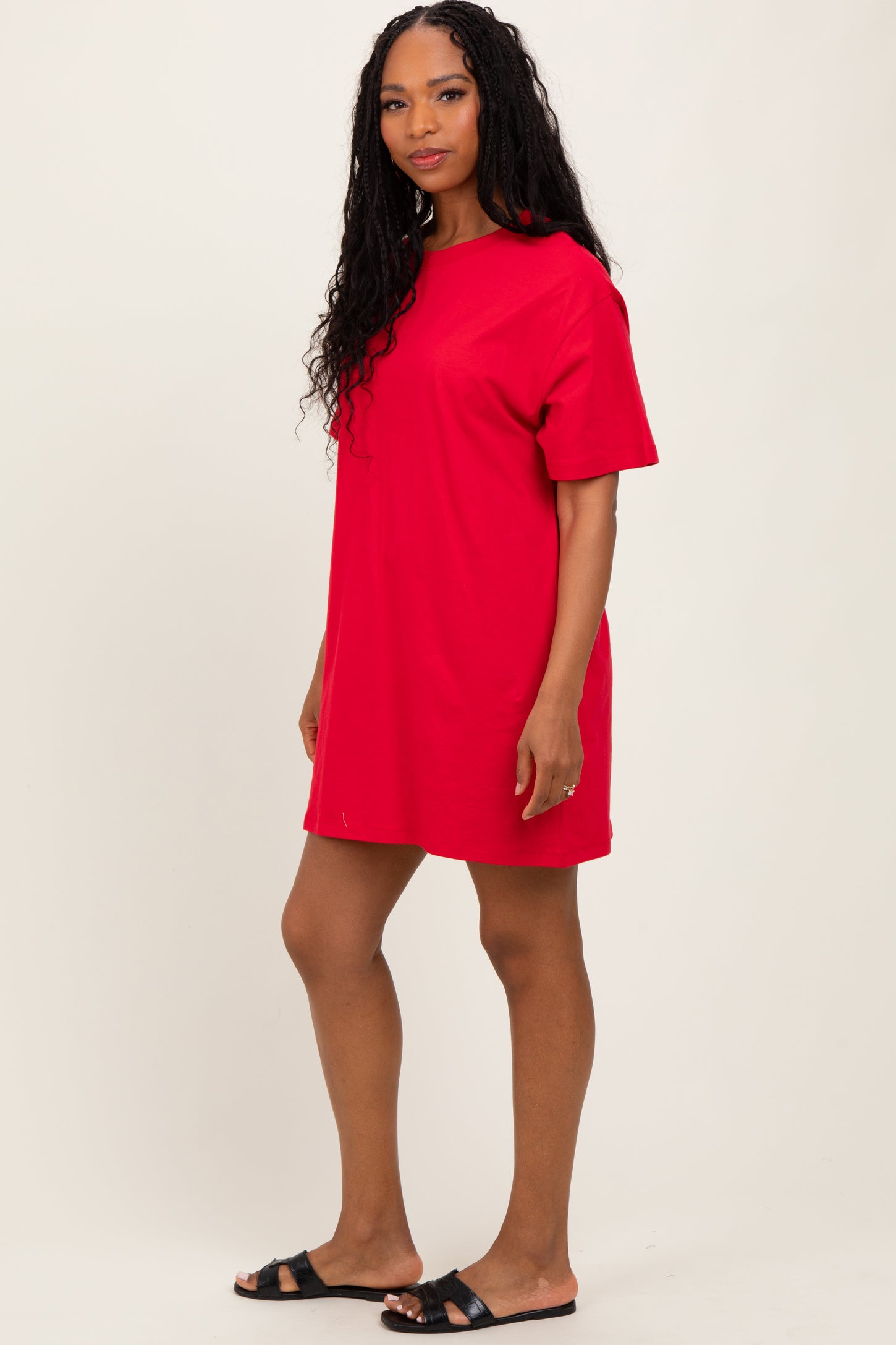 woman wearing a red oversized t-shirt dress and black slide sandals
