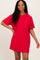 woman wearing a red oversized t-shirt dress with short sleeves and a relaxed fit