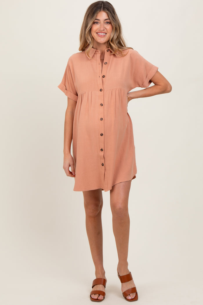 woman wearing a tan short sleeve maternity dress with buttons and a visible baby bump