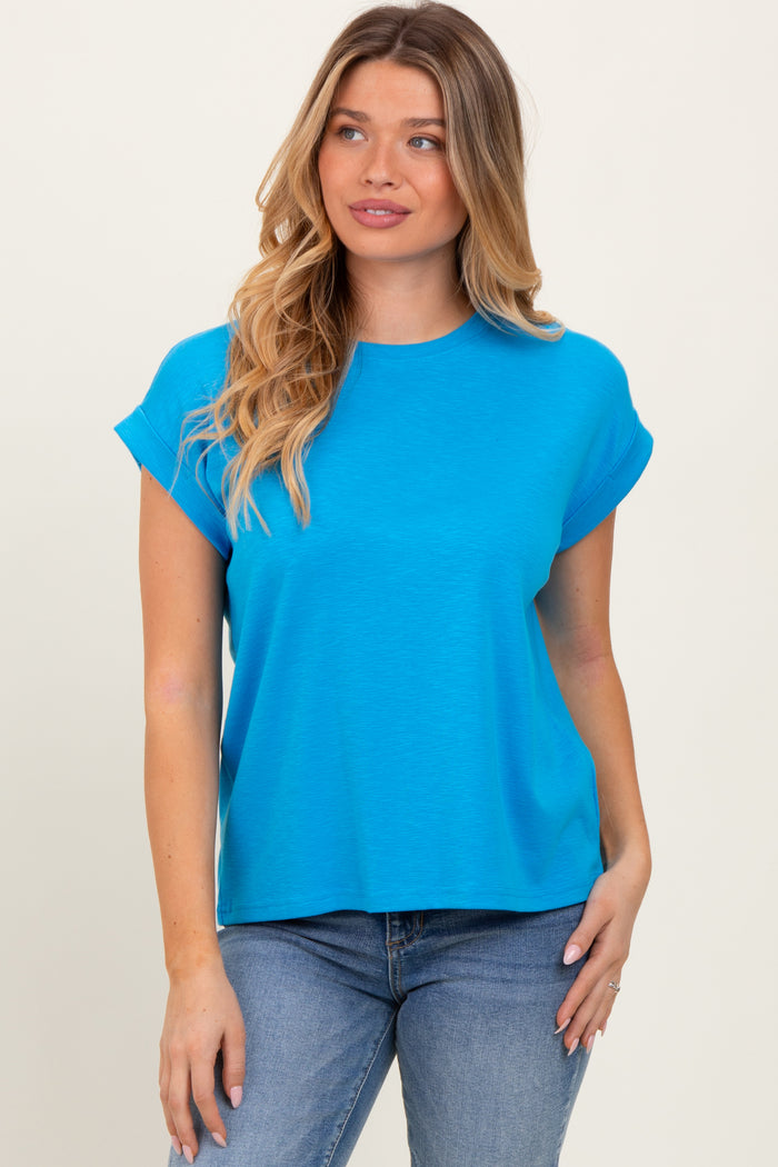 woman wearing a bright blue short sleeve t-shirt with rolled cuffs and relaxed fit, paired with blue jeans