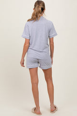 woman wearing a gray maternity loungewear set with short sleeves and shorts, seen from the back