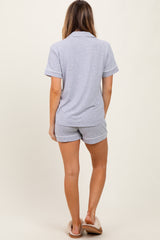 woman wearing a gray short sleeve polo and matching shorts, standing with her back to the camera