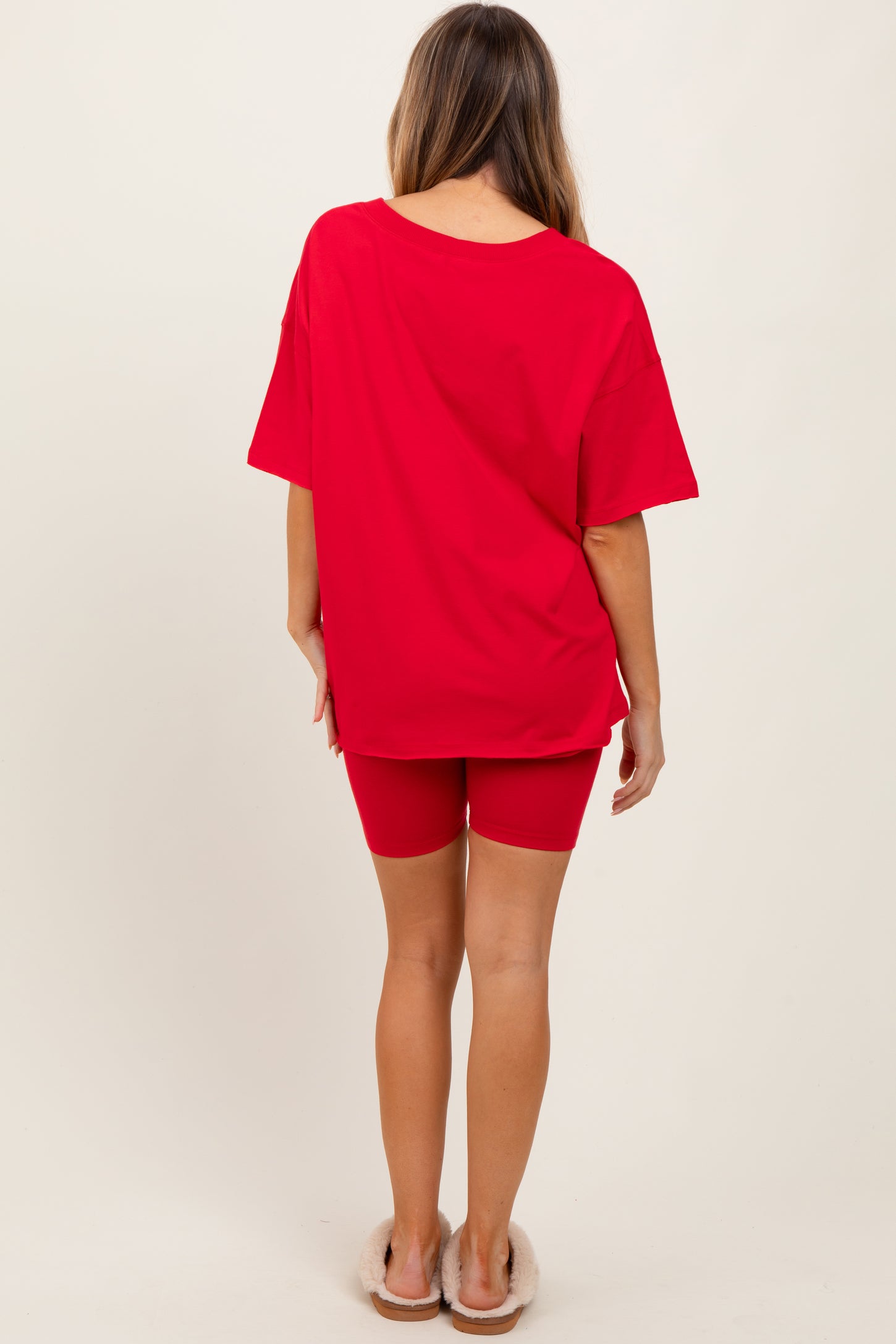 woman wearing a red oversized t-shirt and red cycling shorts, seen from the back