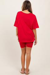 woman wearing a red oversized t-shirt and red cycling shorts, seen from the back