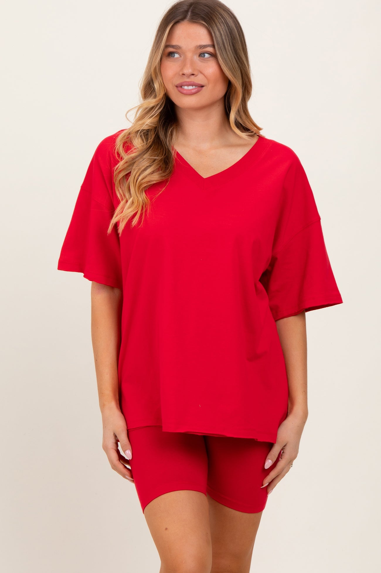 woman wearing a red oversized v-neck t-shirt and matching red bike shorts