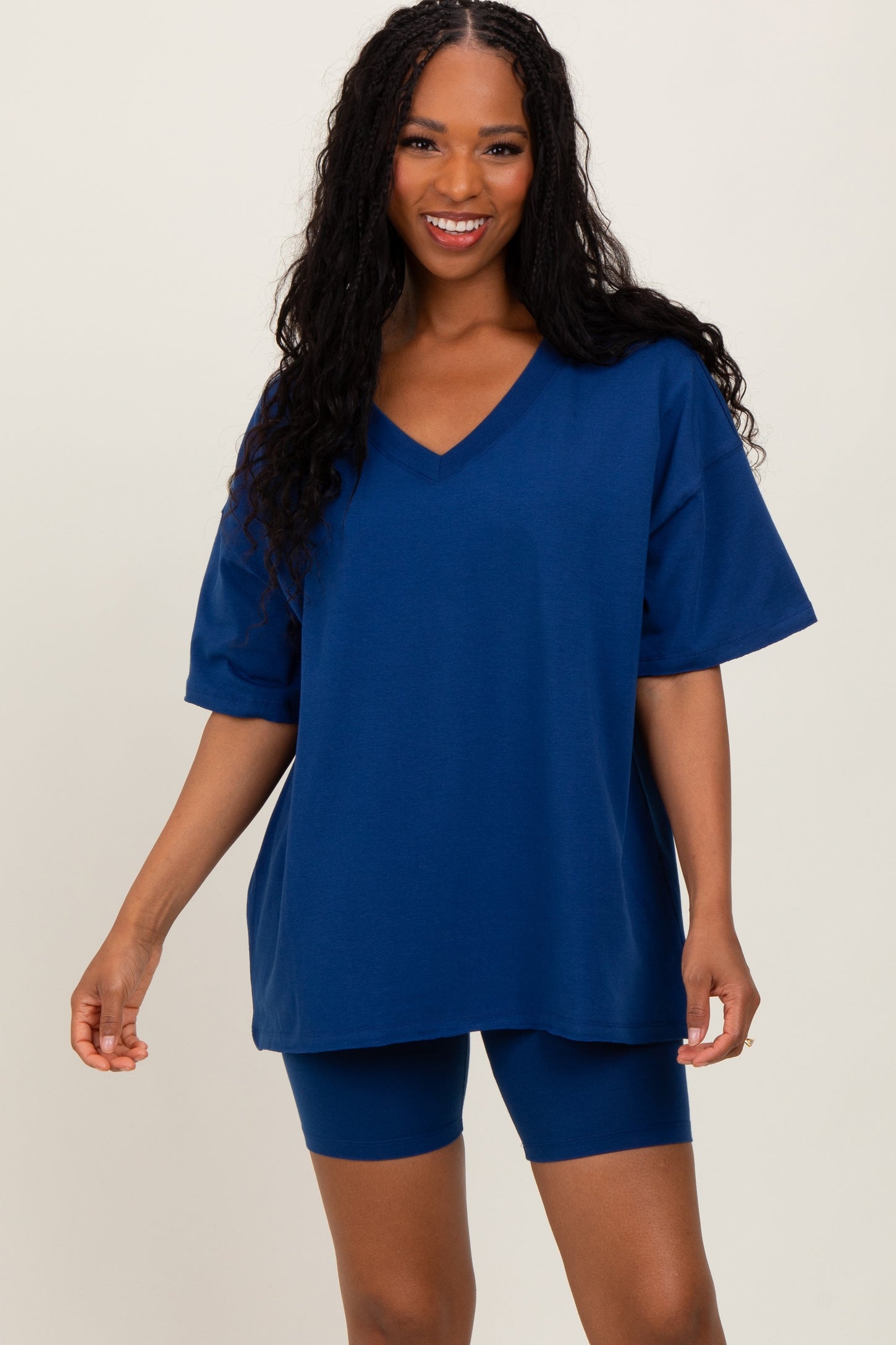 woman wearing a navy blue oversized v-neck t-shirt and matching bike shorts
