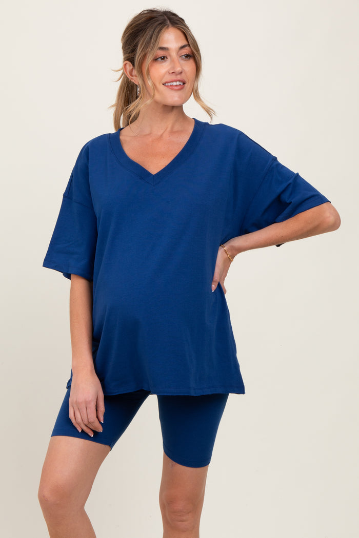 woman wearing a navy blue maternity oversized v-neck tee and matching bike shorts, showing her baby bump