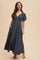 woman wearing a navy blue floral print maxi dress with puff sleeves and a v-neckline