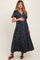 woman wearing a navy floral maternity maxi dress and holding her baby bump