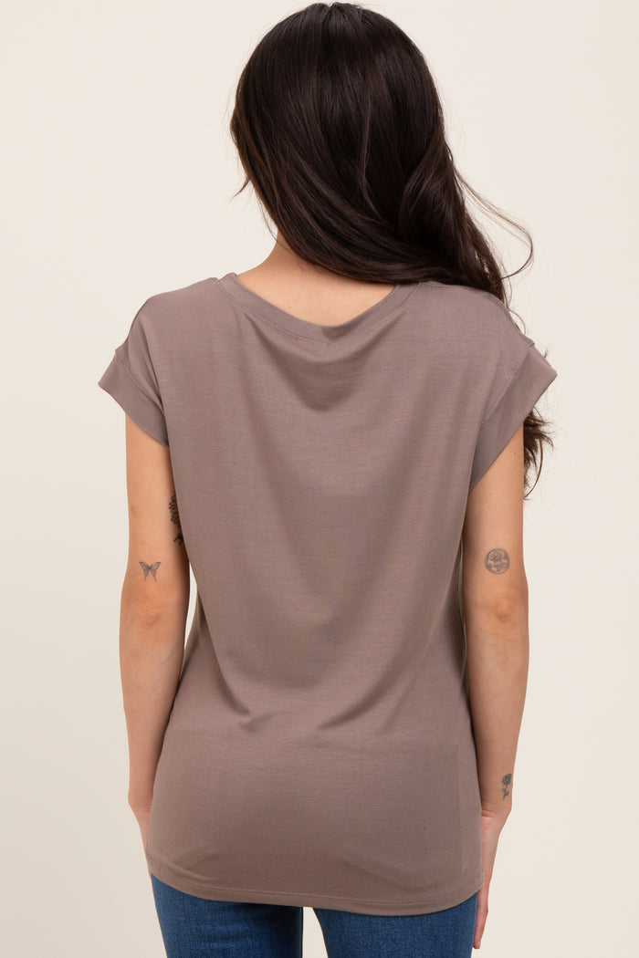 woman wearing a taupe maternity top with rolled short sleeves, showing the back view