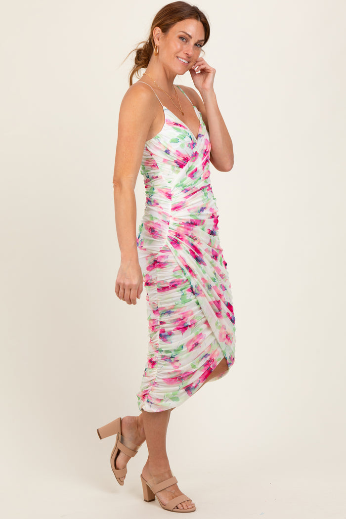 woman wearing a multicolored floral print bodycon dress with ruching and a knee-length hemline