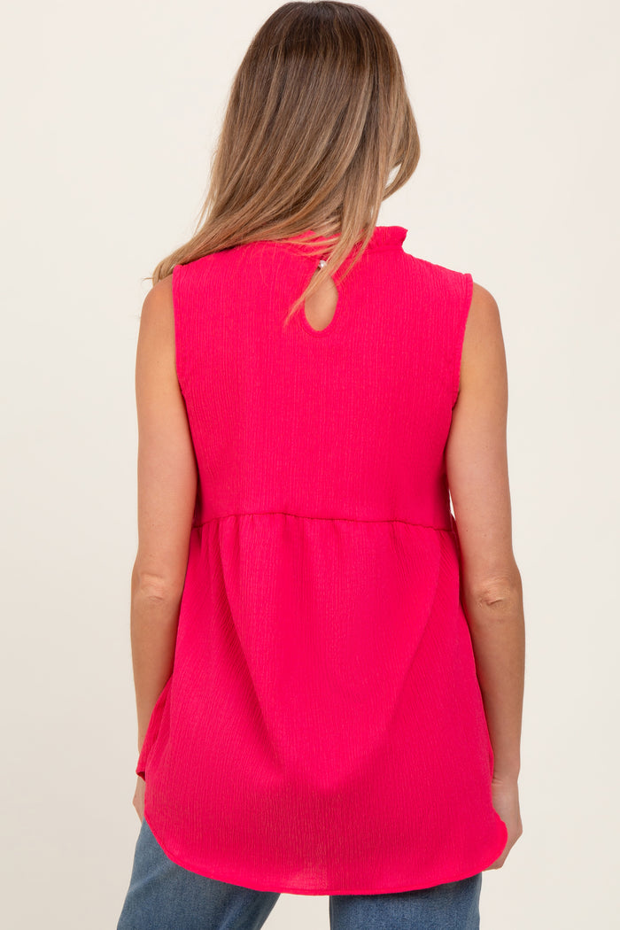 woman wearing a bright pink sleeveless maternity top with a keyhole back design