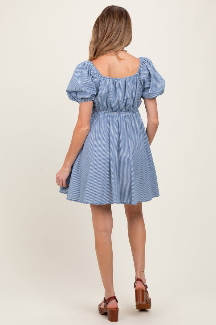 woman wearing a blue striped maternity dress with puff sleeves and a cinched waist, showing the back view