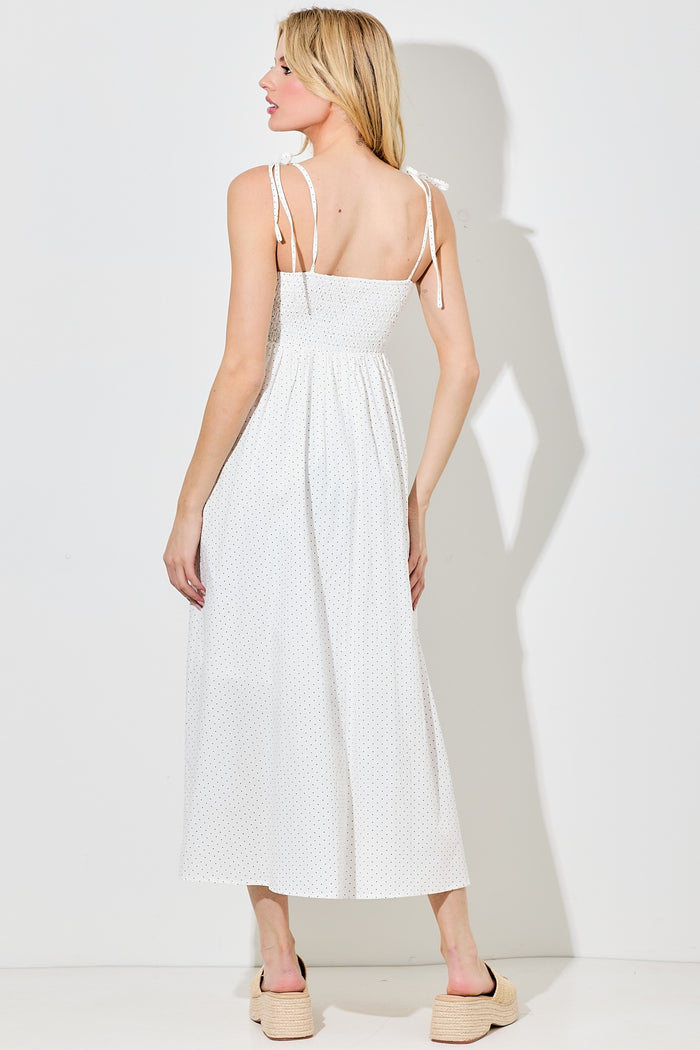 woman wearing a white polka dot maxi dress with tie straps, showing the back and a relaxed silhouette