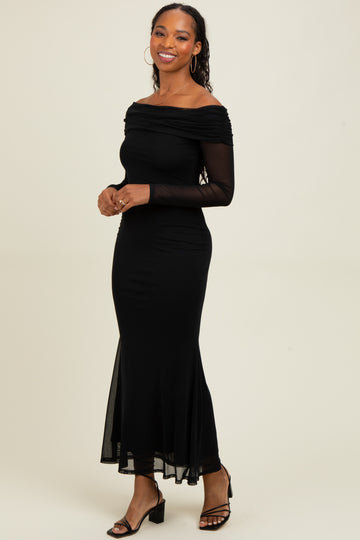 woman wearing a black off-the-shoulder long sleeve dress with a fitted bodice and a flowy hemline