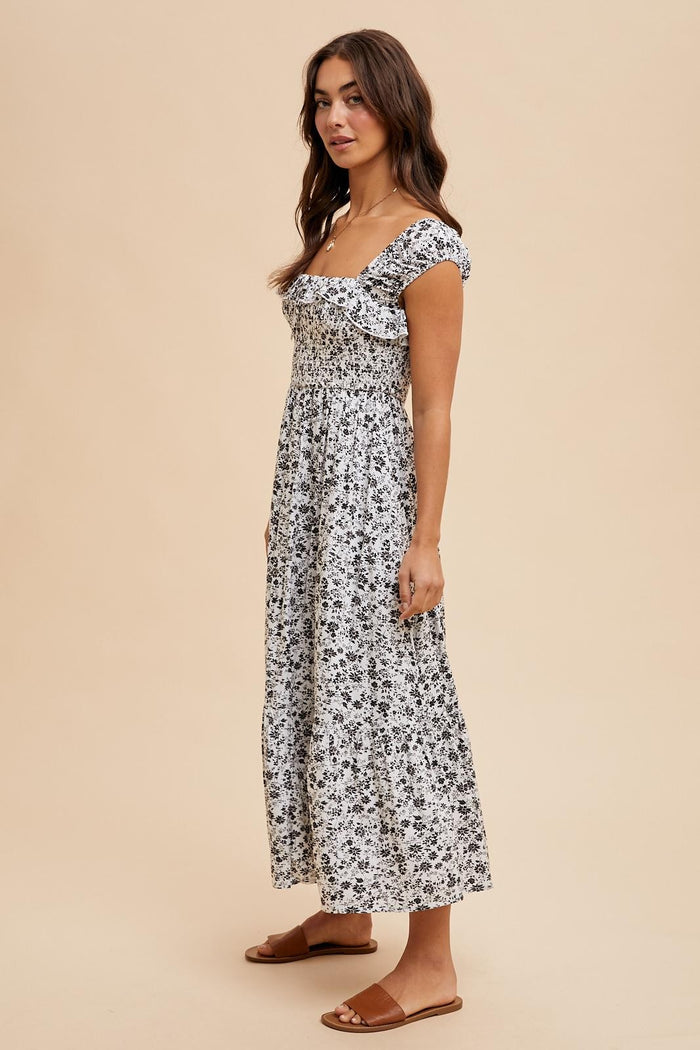 woman wearing a black and white floral maxi dress with short sleeves and square neckline