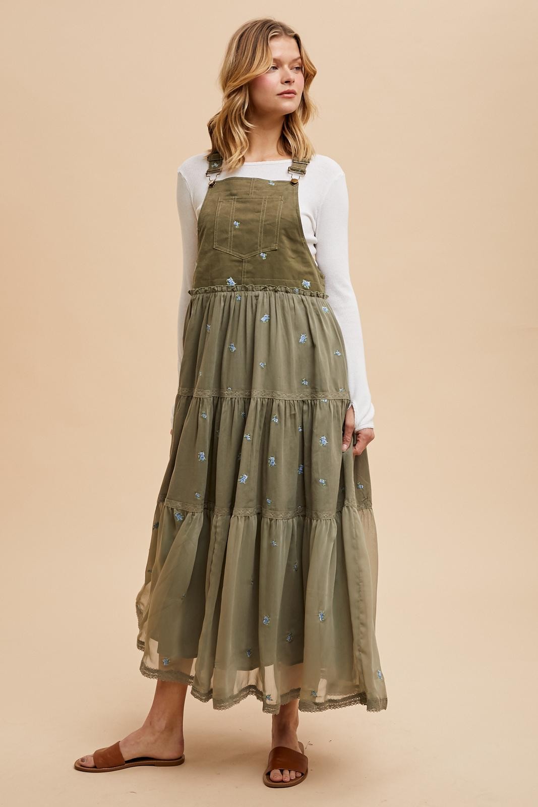 woman wearing an olive green embroidered maxi dress with a tiered design and adjustable straps