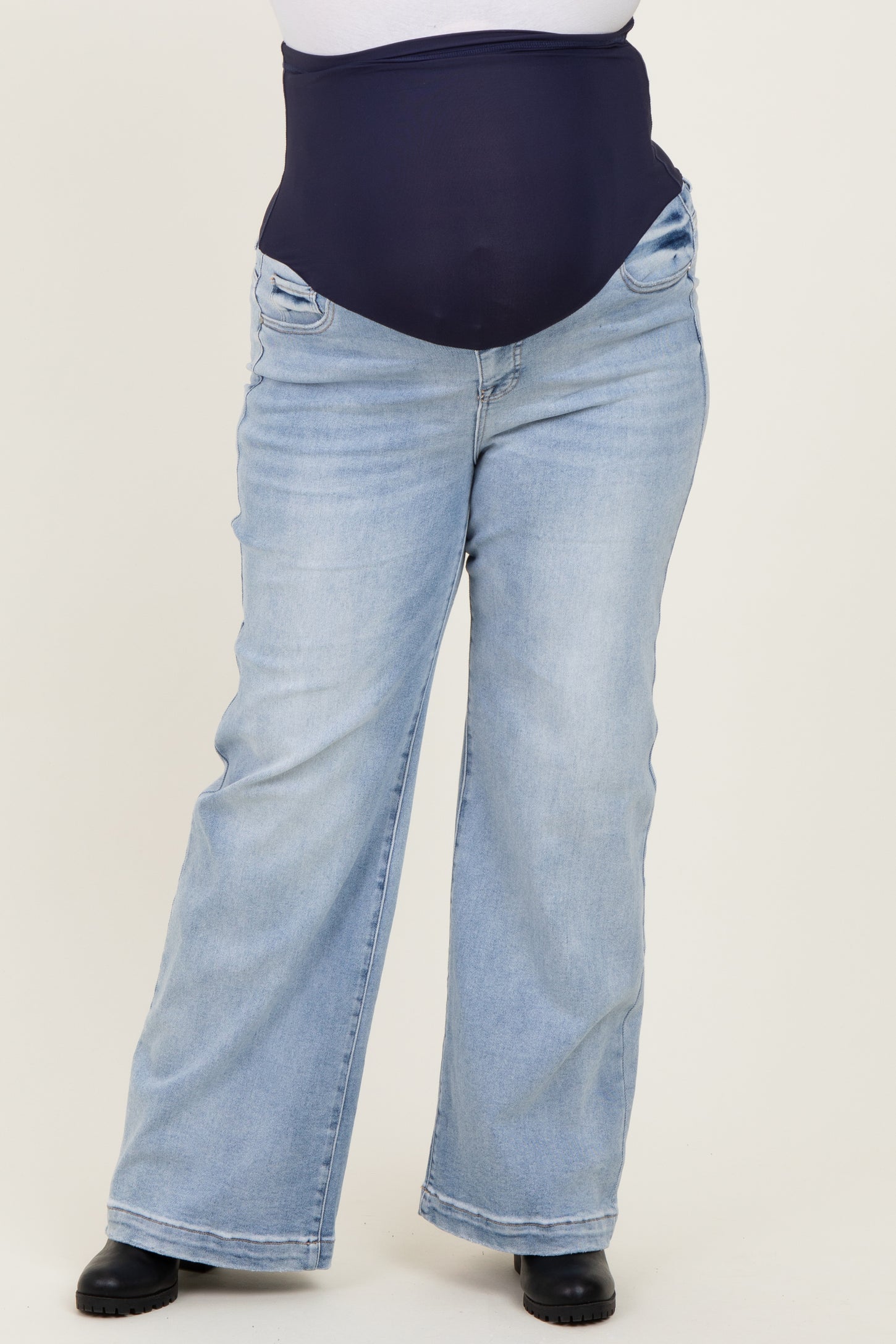 woman wearing light wash maternity plus jeans with a supportive belly band and side pockets