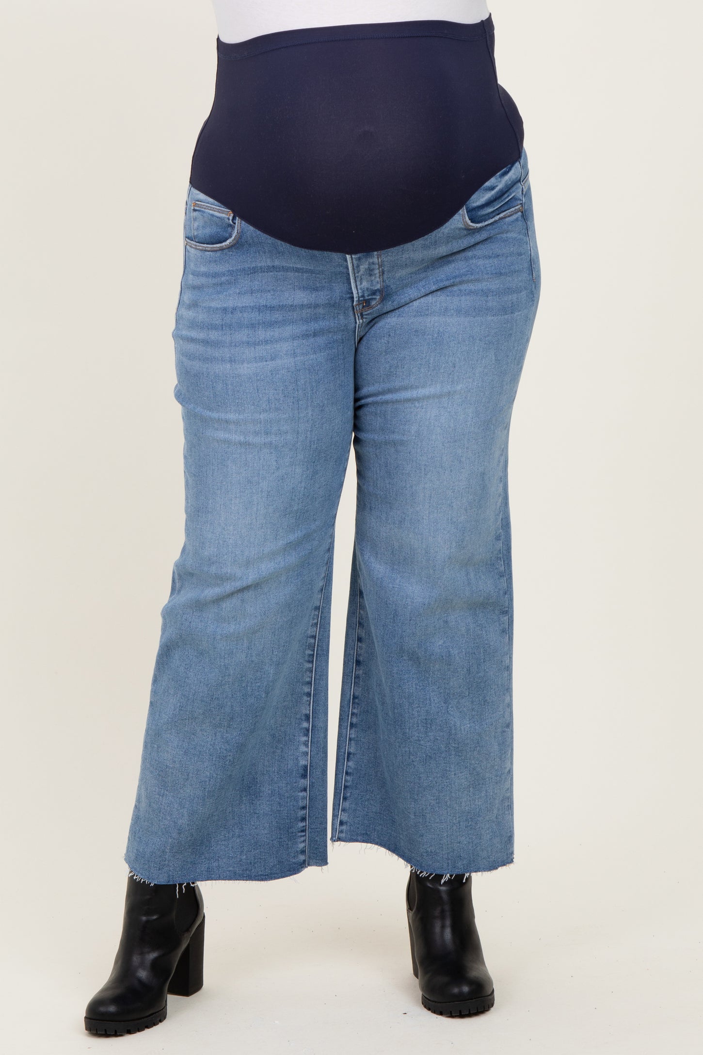 maternity plus size light wash wide leg jeans with a navy supportive belly band and a visible baby bump