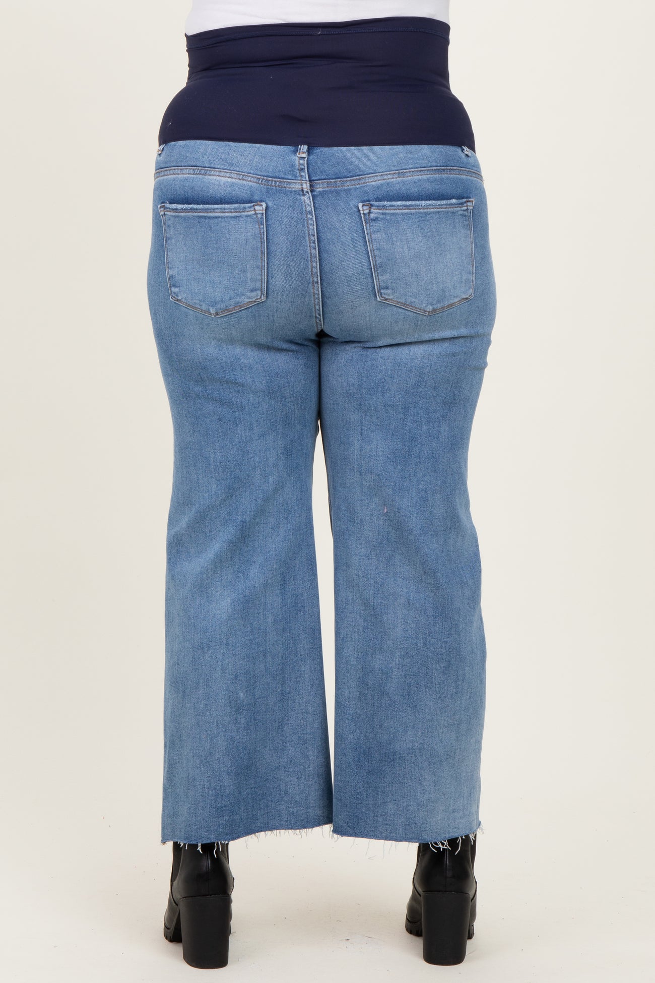 maternity plus denim capri pants in light blue with a stretchy navy waistband and frayed hem detail, shown from the back
