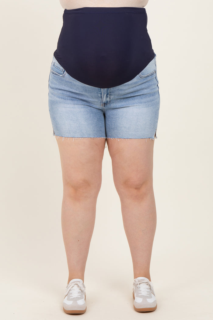 woman wearing dark blue maternity plus denim shorts with a high waistband and frayed hem