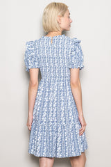 woman wearing a blue floral puff sleeve dress with a tiered skirt, viewed from the back