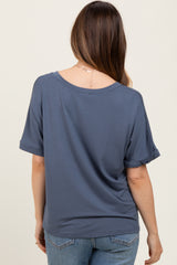 woman wearing a slate blue short sleeve maternity top with rolled sleeves, seen from the back